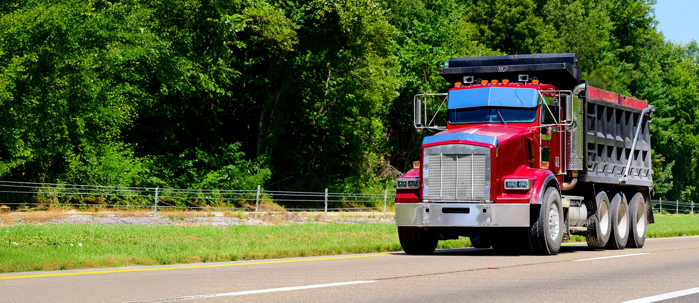 Red dump truck driving on the road